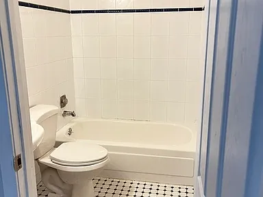 Bathroom with tiled tub surround and mosaic floor