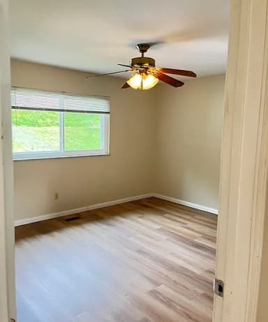 Bedroom with ceiling fan and wood-look flooring